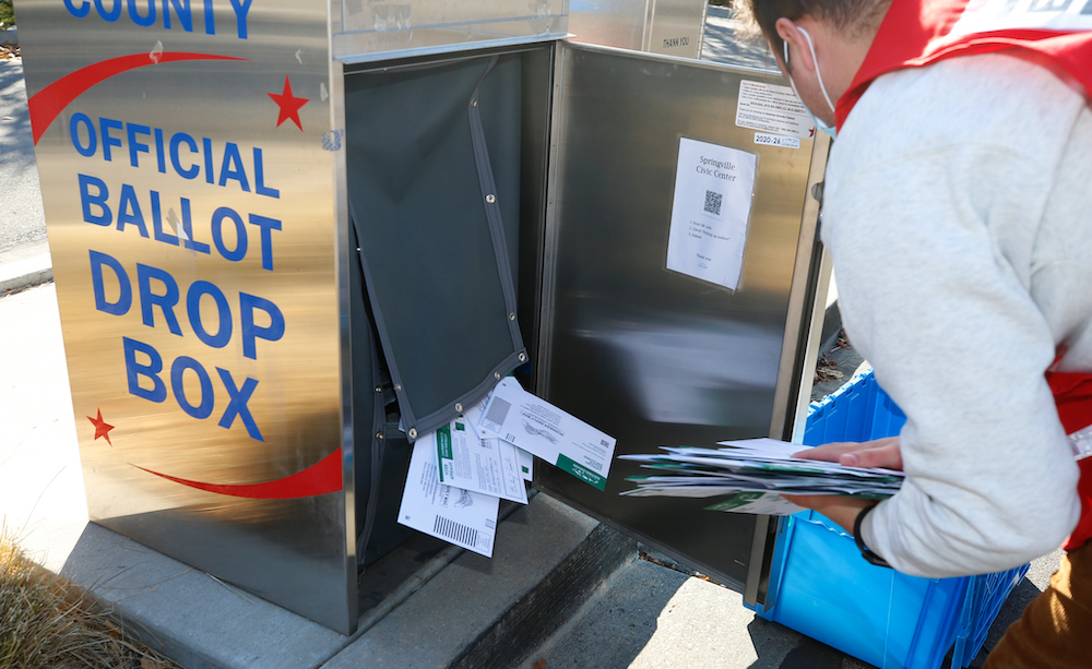 A Utah County Election worker gathers ballots from a drop box on October 26, 2020 in Springville, Utah. (Photo by George Frey/Getty Images)
