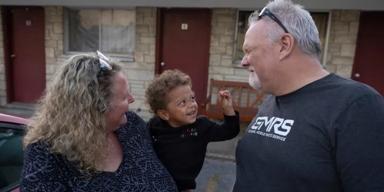Heather and Stephen Casner play with Royce Lingle, 2, during pickup time at the day care center the Casners started in a former motel in rural Anna, Illinois. (Julia Rendleman, for ProPublica and Capitol News Illinois)