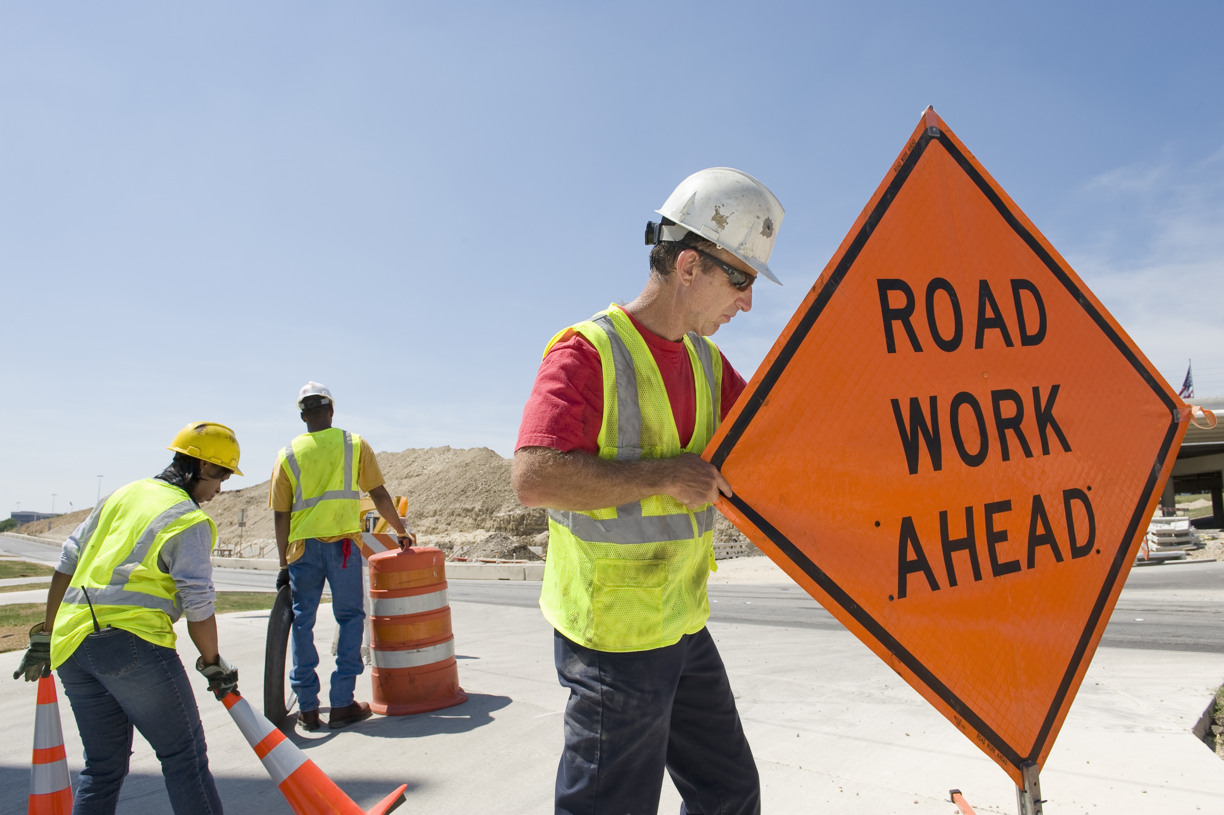 workers moving equipment and road signs on highway workers moving equipment and road signs on highway