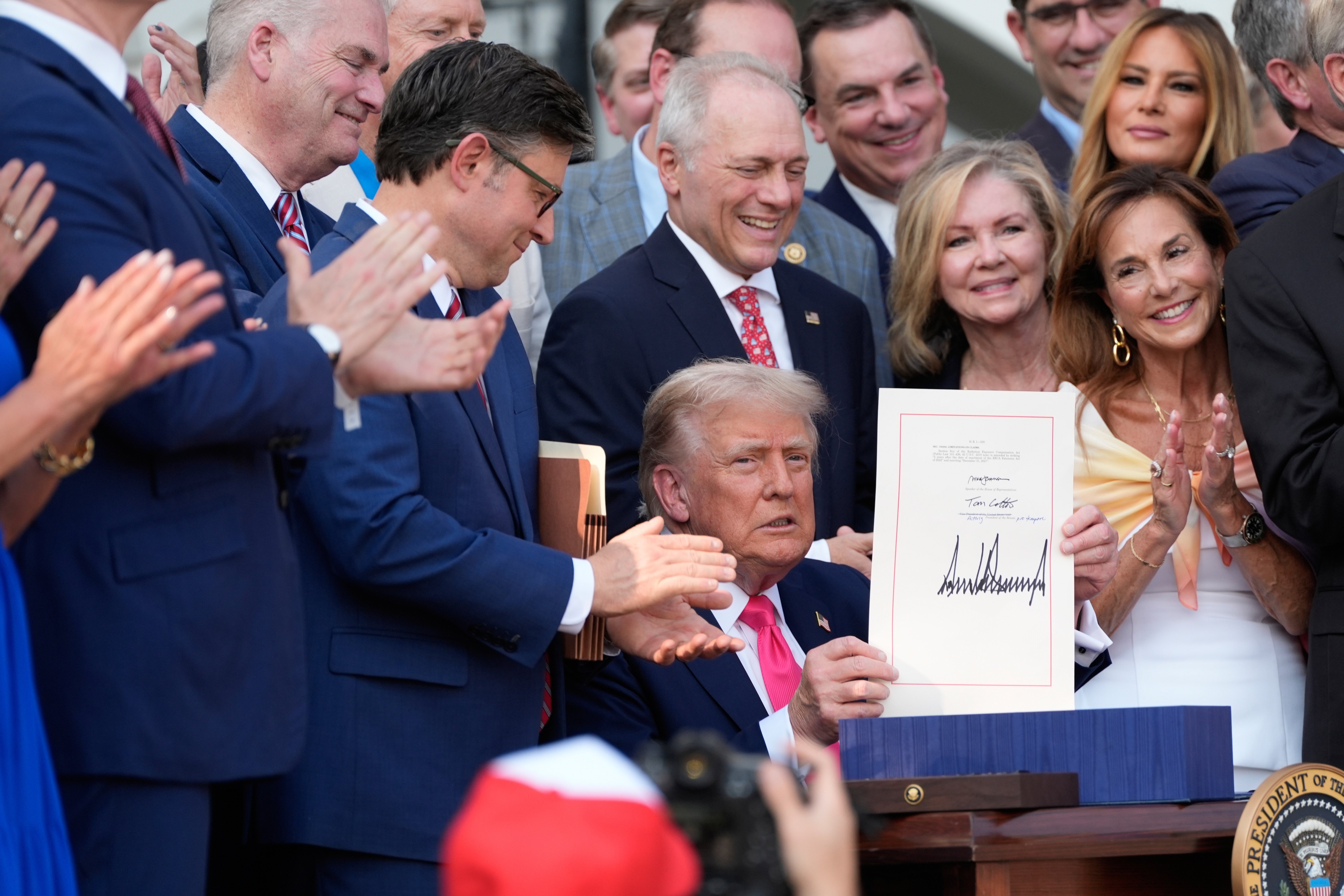 President Donald Trump holds up the "big, beautiful bill" that was signed into law as during a Fourth of July military family picnic on the South Lawn of the White House on July 4, 2025 in Washington, D.C. (Photo by Alex Brandon - Pool/Getty Images)