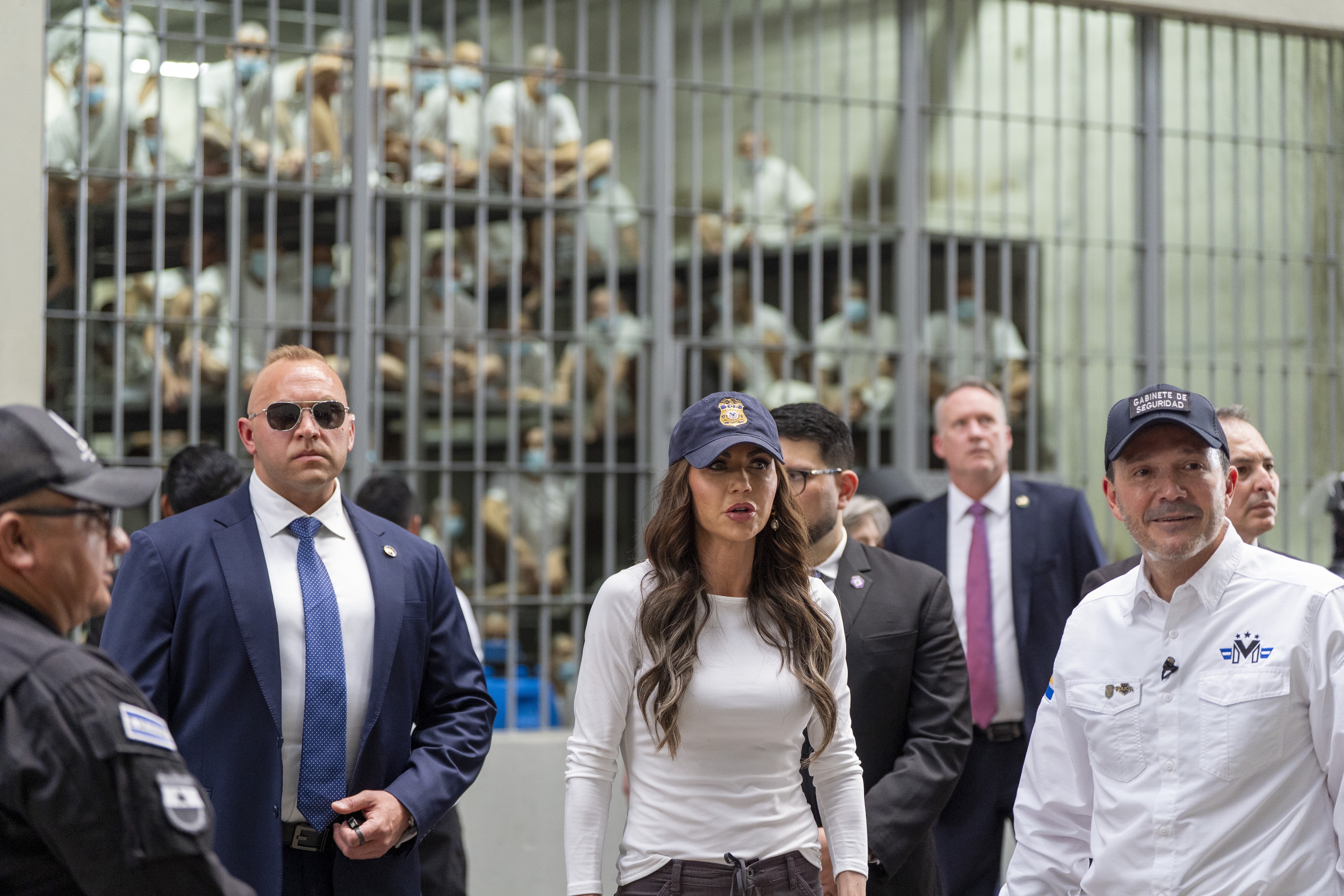 Homeland Security Secretary Kristi Noem, (C), during a tour of the Terrorist Confinement Center (CECOT) on March 26, 2025 in Tecoluca, El Salvador. The Trump administration deported 238 alleged members of the Venezuelan criminal organizations 'Tren De Aragua' and Mara Salvatrucha with only 23 being members of the Mara. Nayib Bukele president of El Salvador announced that his government will receive the alleged members of the gang to be taken to CECOT. (Photo by Alex Brandon-Pool/Getty Images)