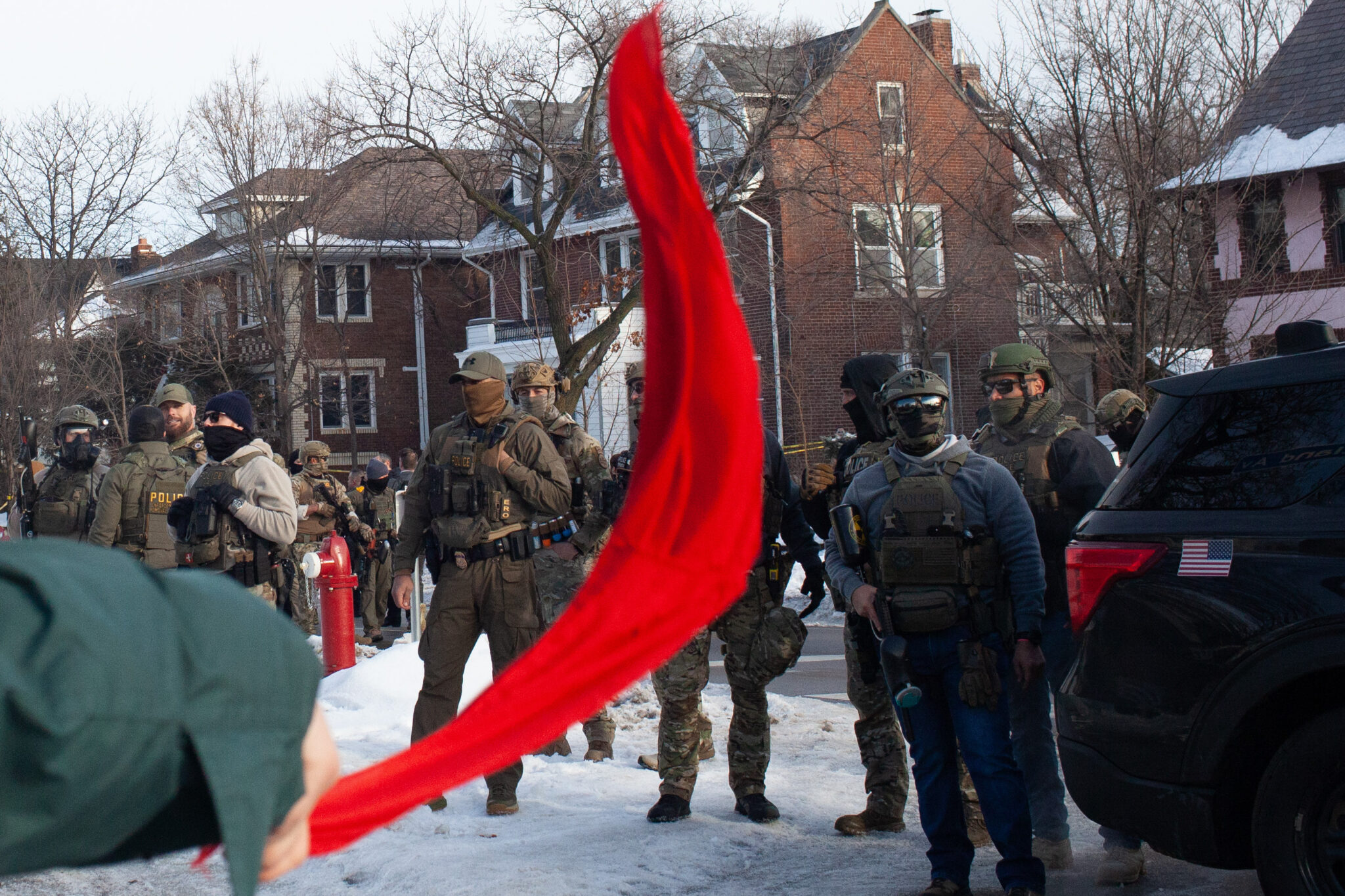 A demonstrator waves a red cloth as hundreds gather after ICE agent Jonathan Ross shot and killed Renee Good through her car window Wednesday, Jan. 7, 2026 near Portland Avenue and 34th Street. (Photo by Nicole Neri/Minnesota Reformer)