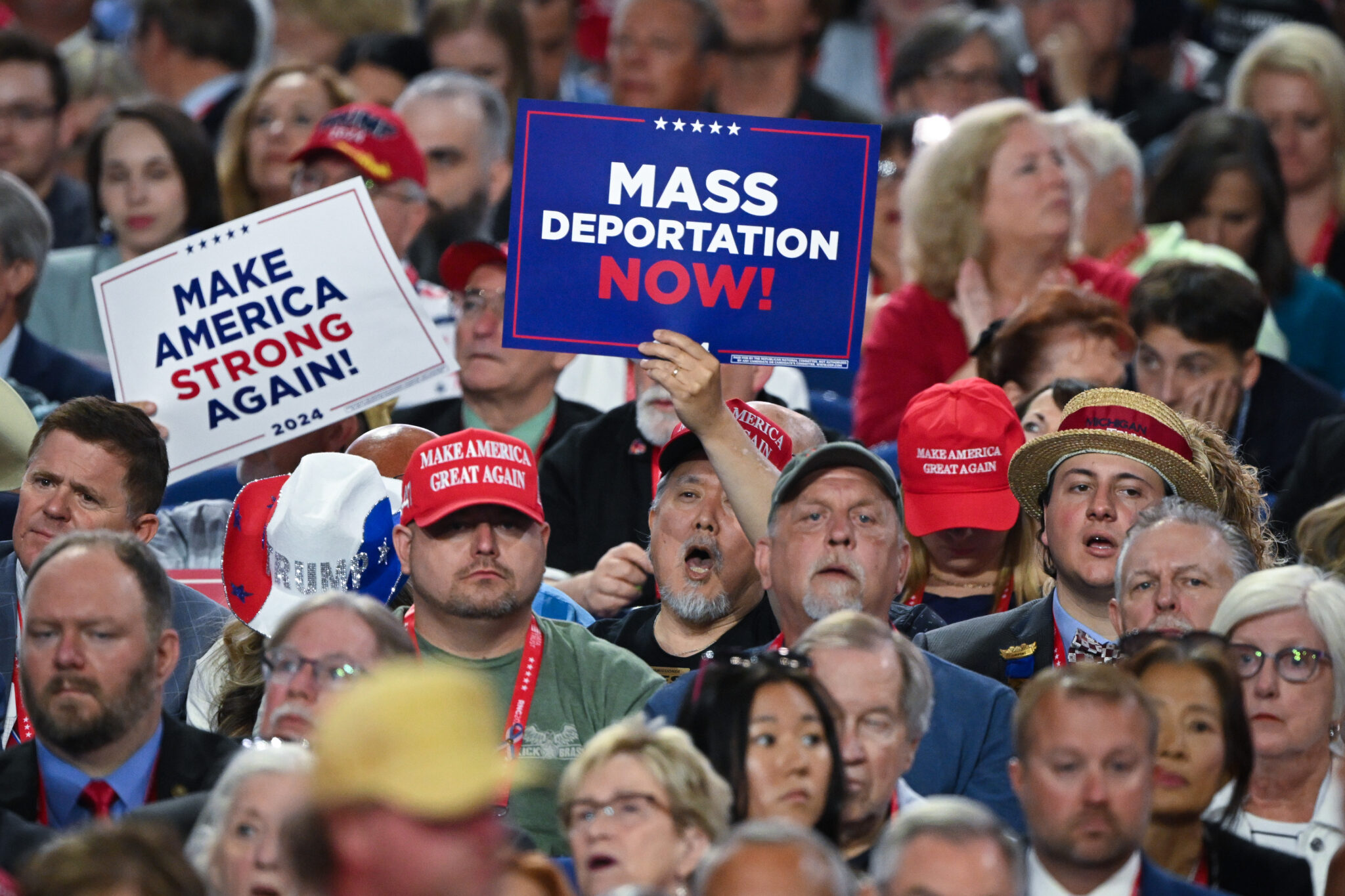 Weekend reads: In a battleground state, it all comes down to voter turnout a Trump supporter holds sign saying "mass deportation now"