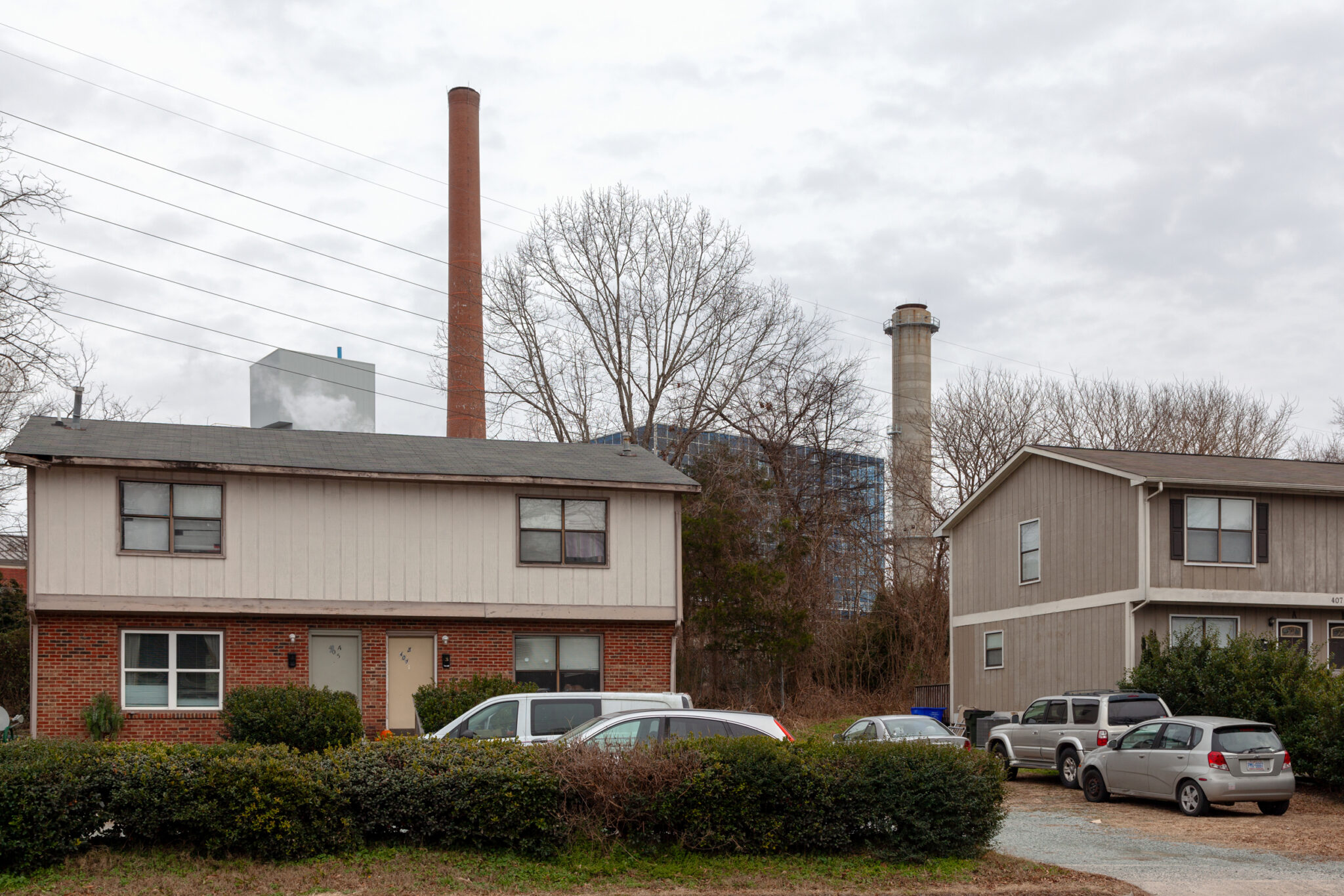 To reduce its carbon footprint, UNC could burn pellets composed of paper and plastic a smokestack looms in the background behind a pair of houses