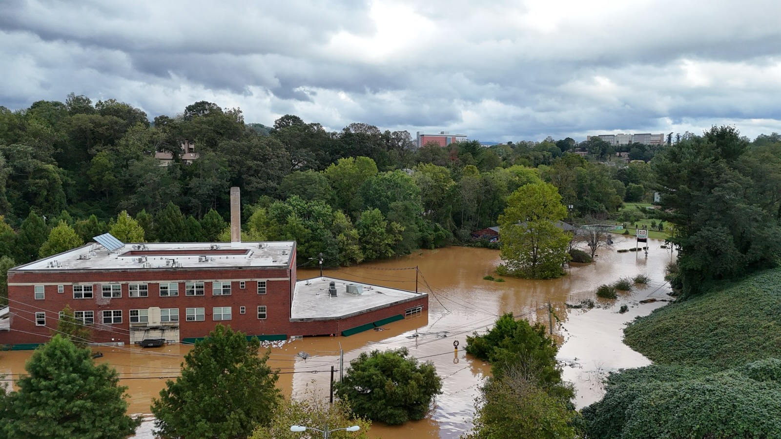 Months after Helene, some western NC businesses reopen — with new debt and financial worries a flooded street and commercial building