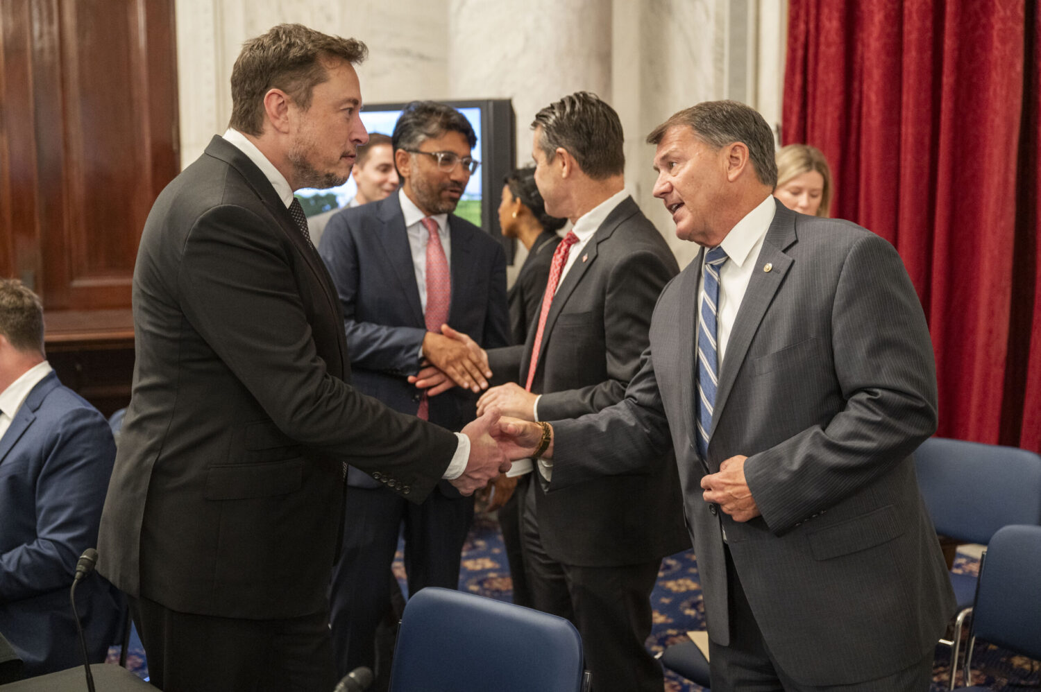 U.S. Senate to examine AI’s wide-ranging impact, Schumer and Rounds say Sen. Mike Rounds, R-South Dakota, right, shakes hands with Elon Musk, CEO of Tesla, X and SpaceX, on Sept. 13, 2023, in Washington, D.C., during a discussion about artificial intelligence. (Official U.S. Senate photo by Dan Rios)