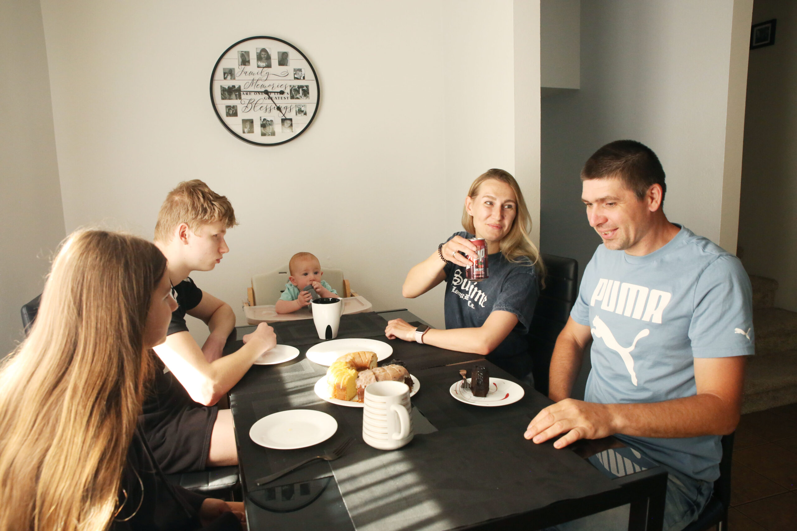 ‘This is our home’: Ukrainians settled in SD fear Trump-Noem policies will force them to leave The Biliaze family sit and talk amongst themselves at the kitchen table on May 12, 2025. (Makenzie Huber/South Dakota Searchlight)