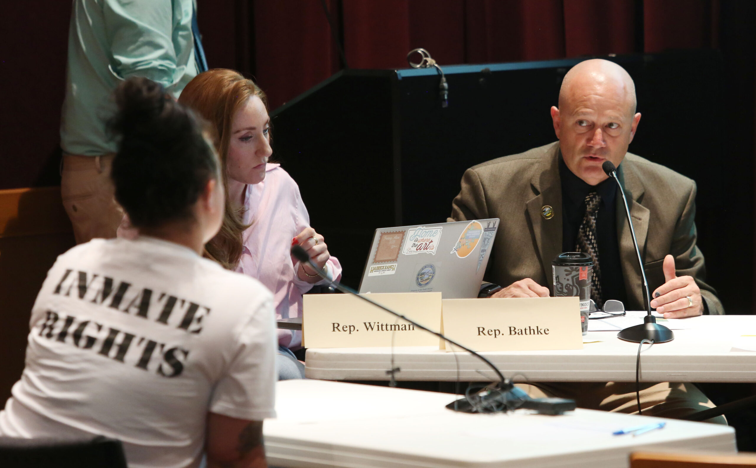 Legislative group studies SD’s high incarceration rate, overrepresentation of Indigenous prisoners Rep. Jeff Bathke, R-Mitchell, responds to questions asked by Linsey Sapp, who wears an "Inmate Rights" shirt and whose husband is incarcerated, at an Initial Incarceration, Reentry Analysis, and Comparison of Relevant States Interim Committee meeting in Sioux Falls on June 24, 2025. (Makenzie Huber/South Dakota Searchlight)