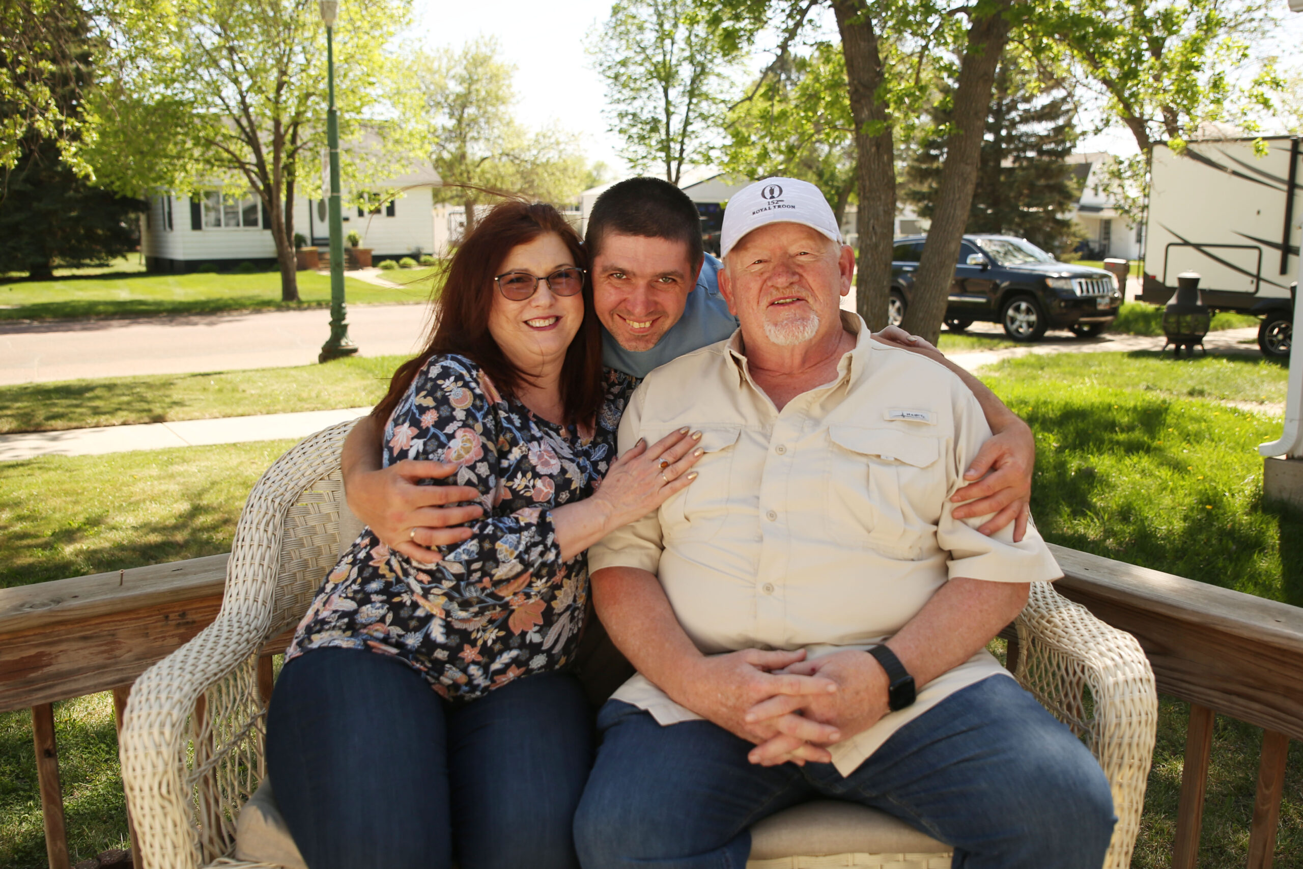 ‘This is our home’: Ukrainians settled in SD fear Trump-Noem policies will force them to leave (Left to right) Susan Buhler, Valerii Biliaze and Bruce Buhler pose for a photo out side of Biliaze's house in Watertown on May 12, 2025. (Makenzie Huber/South Dakota Searchlight)