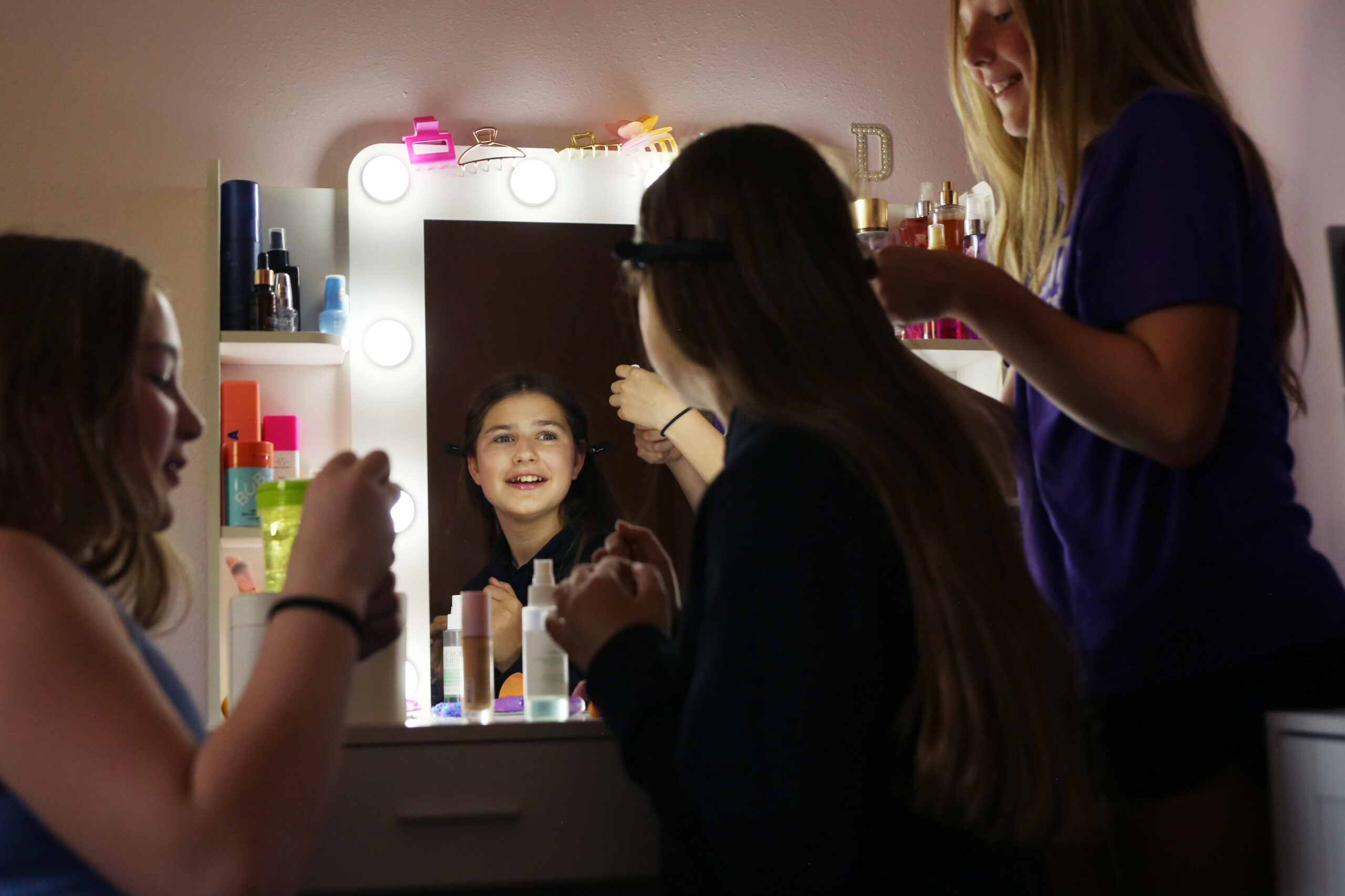 ‘This is our home’: Ukrainians settled in SD fear Trump-Noem policies will force them to leave Friends put make up on Dominika Biliaze after school on May 12 in her bedroom in Watertown. (Makenzie Huber/South Dakota Searchlight)