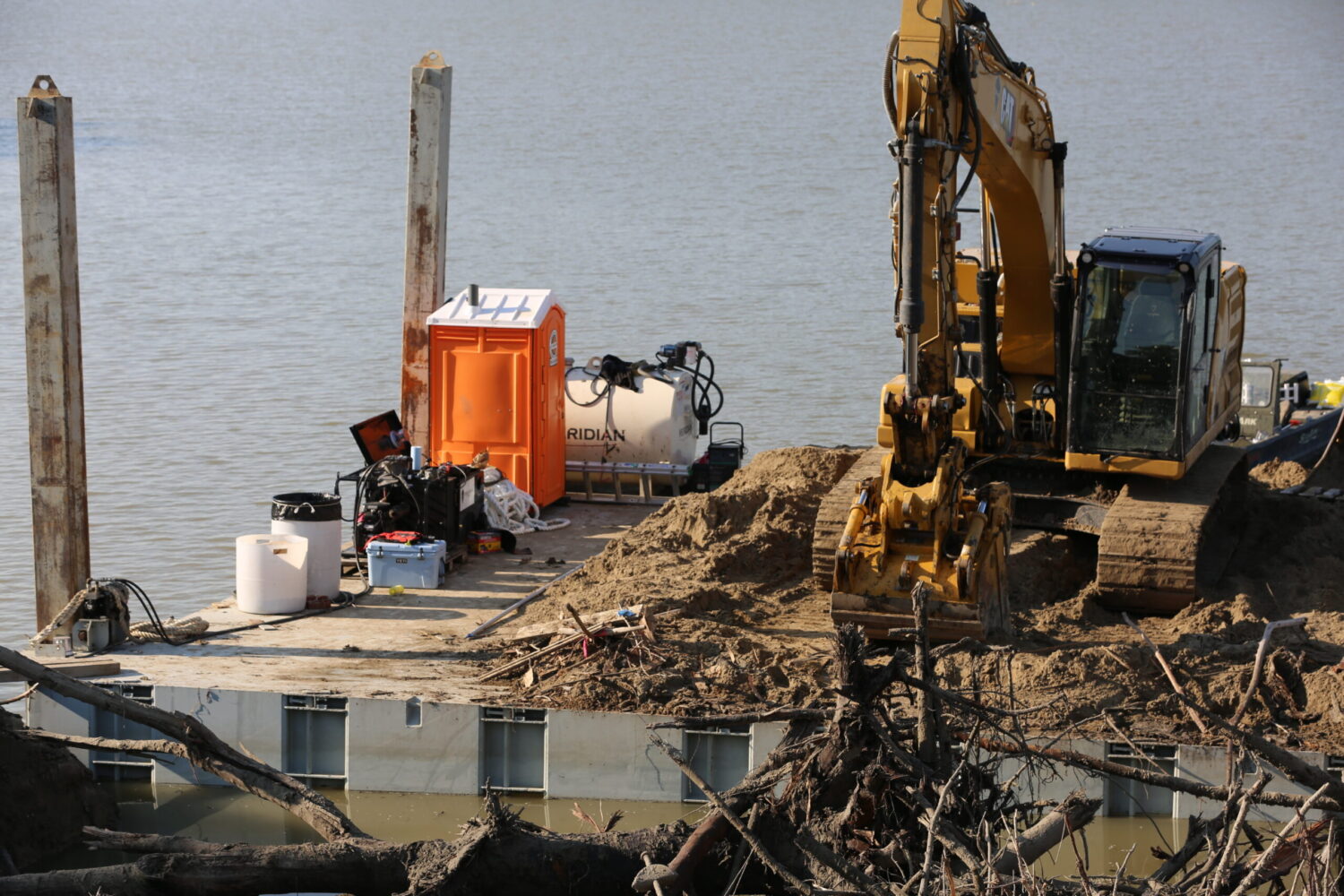 ‘Like we don’t exist’: One year after the flood, a sense of abandonment lingers in McCook Lake An excavator sits on a floating barge, cleaning sediment and debris from McCook Lake on June 11, 2025. (Joshua Haiar/South Dakota Searchlight)