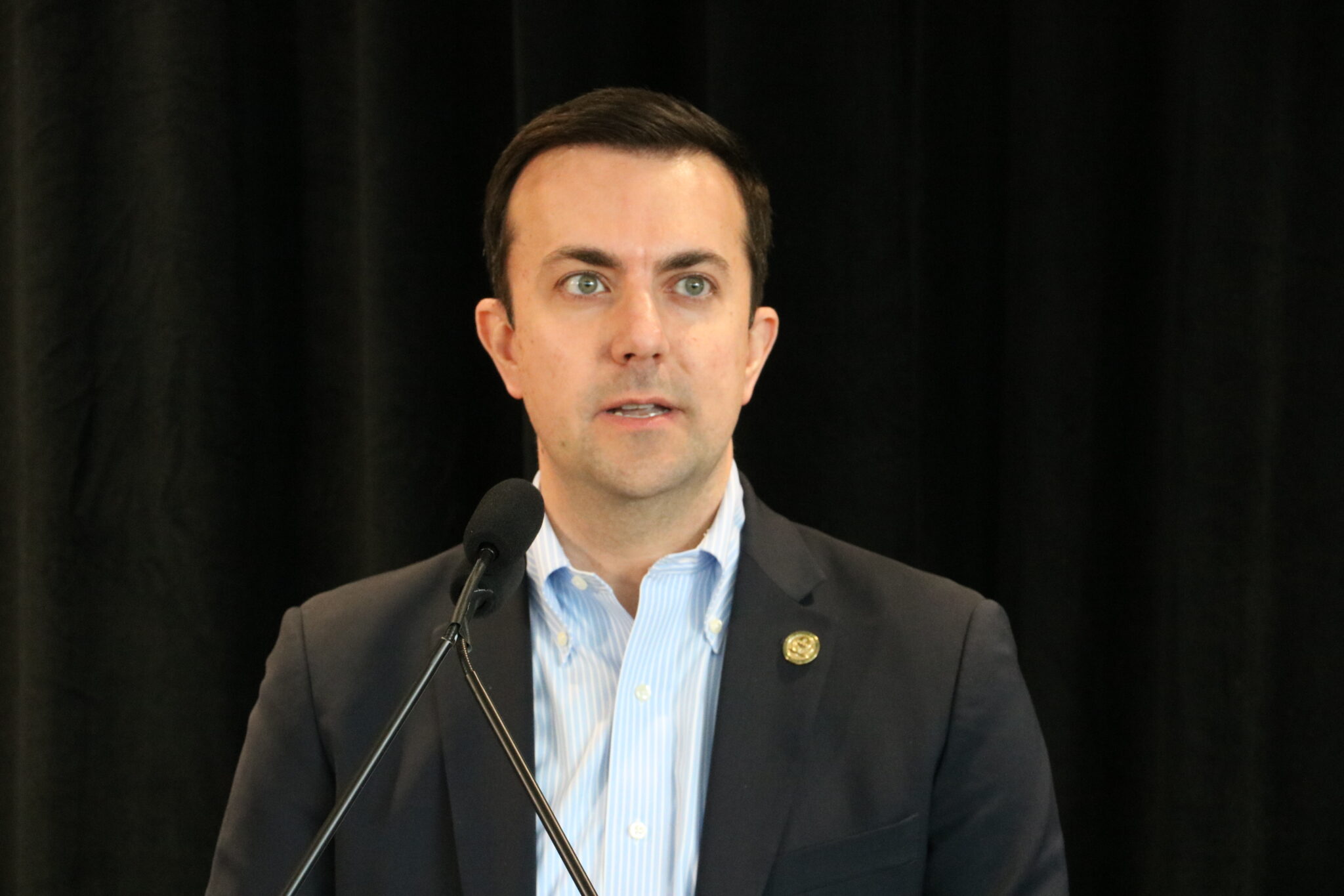 David Fotouhi in front of a microphone.