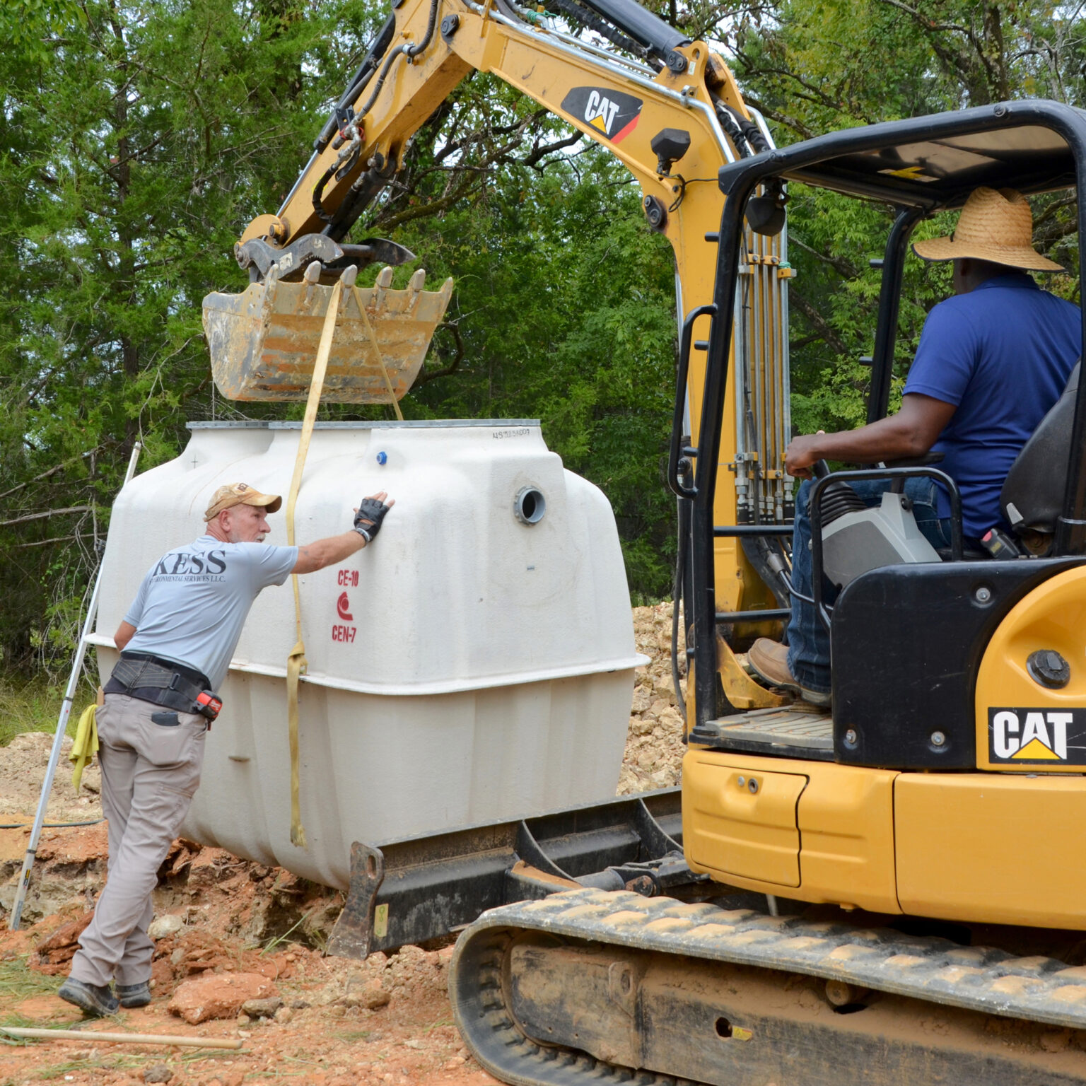 Alabama slowly bringing sanitation equity to rural Black communities after settlement A man with his hands on a larger plastic container with a power shovel nearby
