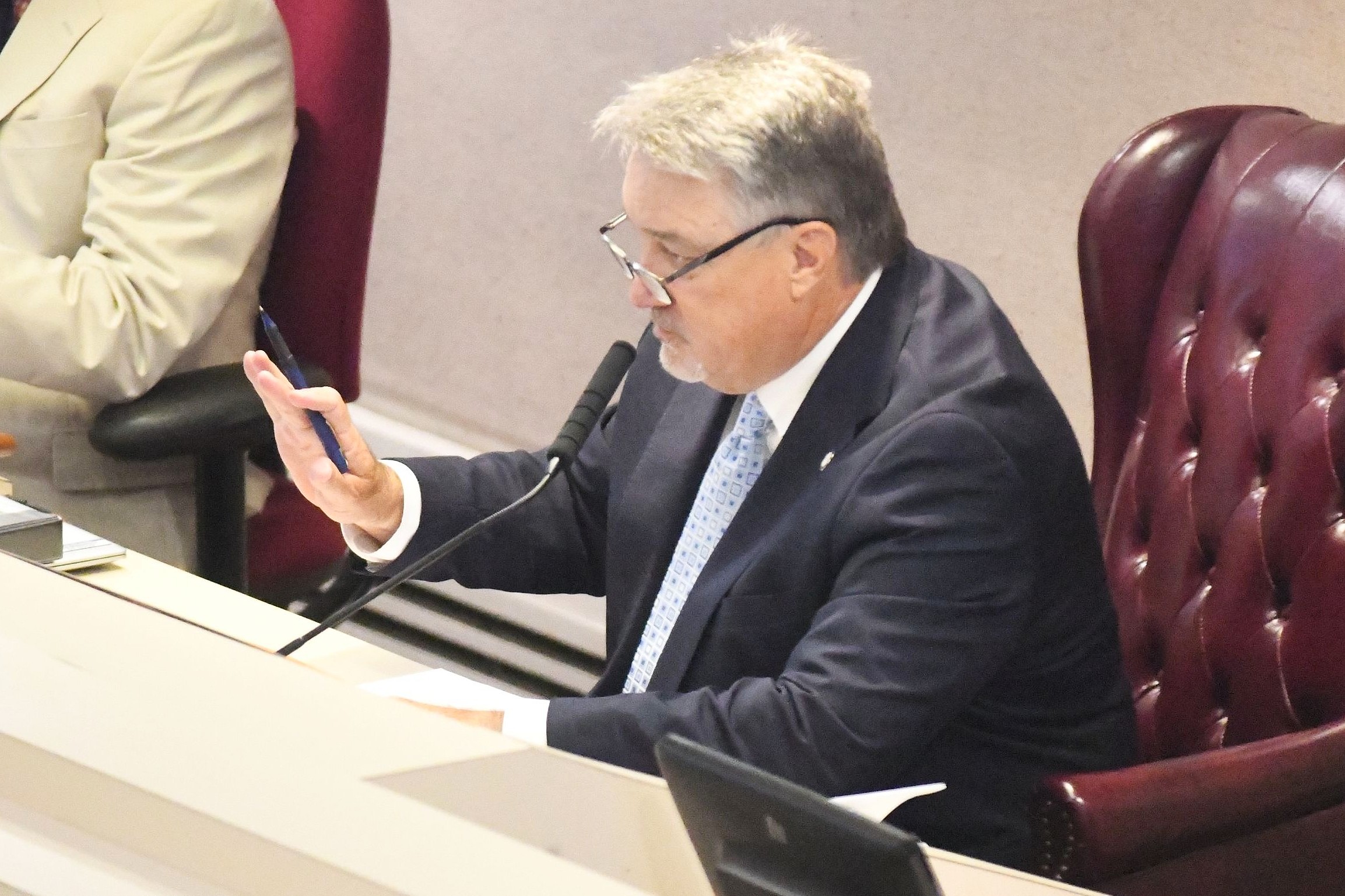 Alabama House and Senate clash over local legislation as session nears end A man in a dark suit and light blue tie holding up his right hand in a gesture to stop.