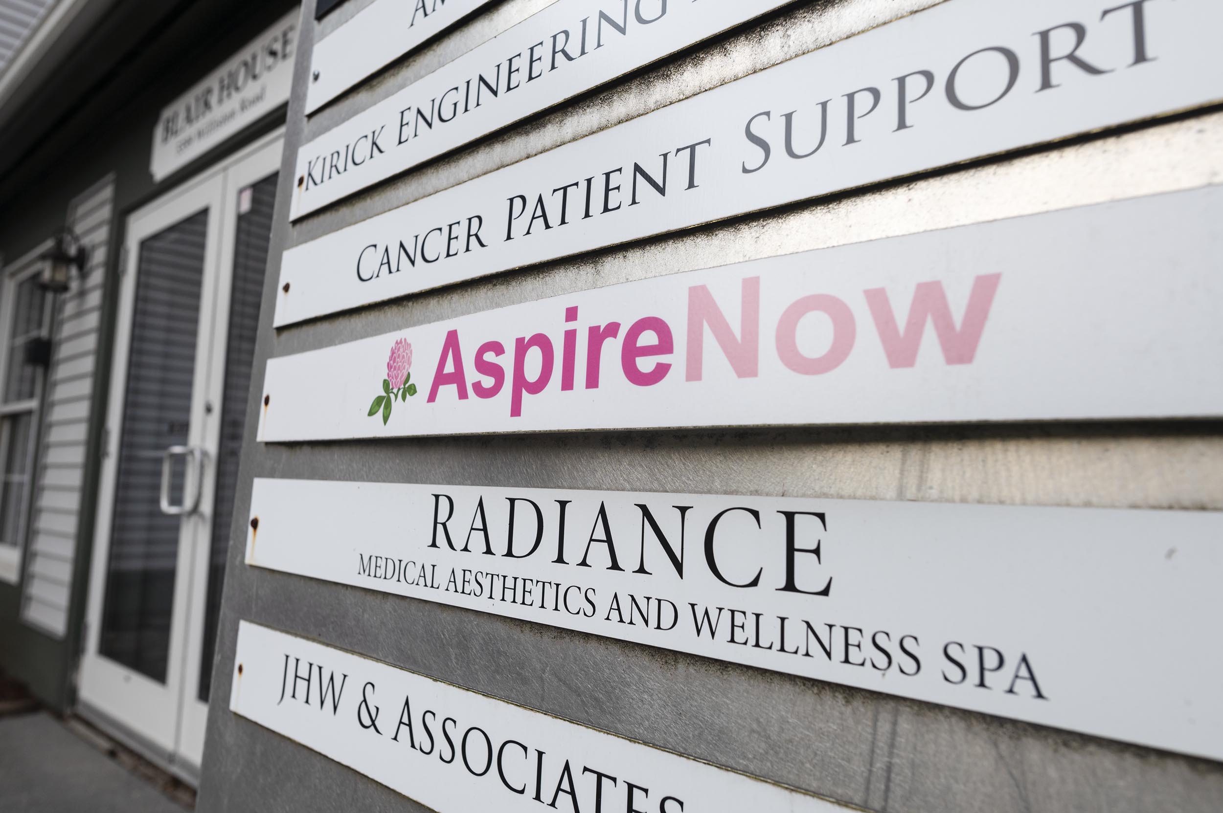 Anti-abortion advocates drop federal lawsuit against Vermont after lawmakers nix language targeting crisis pregnancy centers A wall-mounted directory sign lists several business names, including "AspireNow" highlighted in pink, at the entrance of a commercial building.