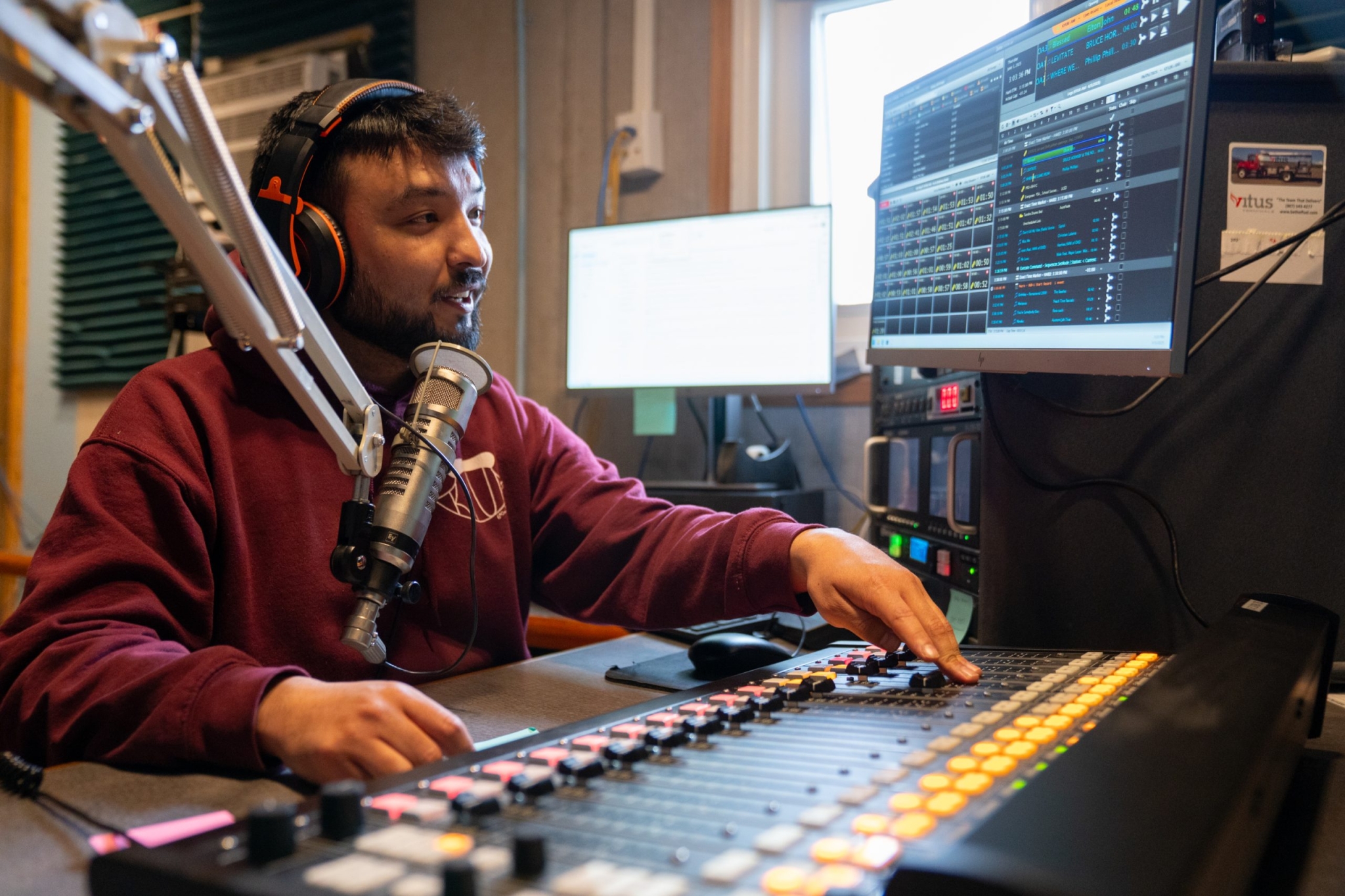 What defunding public media would mean for the West Mathew Hunter, KYUK radio producer, operates the board for one of the station’s many local call-in shows. (Photo by MaryCait Dolan/KYUK)