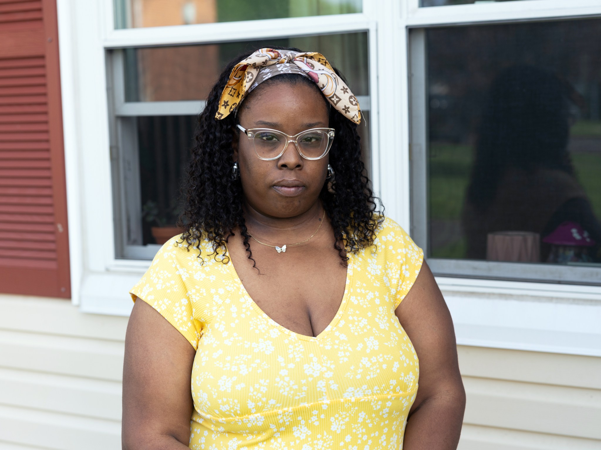 Connecticut’s new towing law will help some, but not all, drivers. Here’s what they told us. Carr, a woman wearing glasses and a bandana, stands outside of a house.