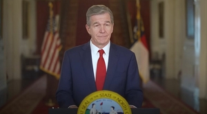 Gov. Roy Cooper speaks at a podium