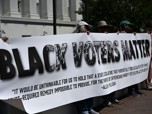 A group of protestors hold a banner saying “Black Voters Matter” with a quote from Allen v. Milligan, a 2023 case that required Alabama to draw a second congressional district to give Black voters an opportunity to elect their preferred leaders, on May 4, 2026 at the Alabama Statehouse in Montgomery, Alabama. (Photo by Brian Lyman/Alabama Reflector)