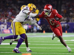 Amare Thomas #0 of the Houston Cougars gives a stiff arm to Tamarcus Cooley #0 of the Louisiana State Tigers in the second half during the Kinder's Texas Bowl at NRG Stadium on Dec. 27, 2025 in Houston, Texas. (Photo by Tim Warner/Getty Images)