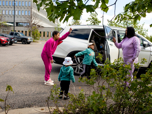 Genesis Mendoza and her daughter Aranssa, 10, hold up a drawstring like a jump rope for Mateo, 4, and Moises, 2, outside the Whipple Federal Building as they wait for a volunteer to bring paperwork before turning themselves in to immigration authorities Wednesday, May 20, 2026. (Photo by Nicole Neri/Minnesota Reformer)