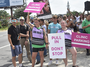 Clinic escorts direct traffic in front of anti-abortion protesters outside A Preferred Women’s Health Center of Atlanta in Forest Park, Ga., in July 2023. A new report detailing an increase in threats of violence against abortion clinics comes as the Trump administration has deprioritized enforcement of a law meant to protect access to the facilities. (Photo by Ross Williams/Georgia Recorder)