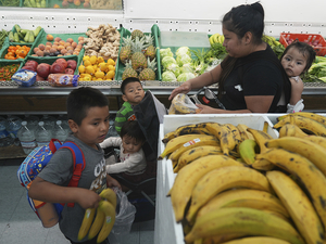 An immigrant mother originally from Guatemala purchases fresh fruits for her children with the balance left on her California EBT (Electronic Benefit Transfer) card used for SNAP benefits, in Los Angeles, Friday, Oct. 31, 2025. Wyoming's SUN Bucks purchases are subject to the same rules as SNAP for grocery purchases within the program's 121-day summer timeline. (AP Photo/Damian Dovarganes)