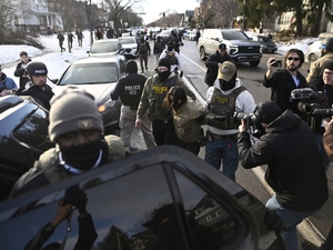 An observer is detained by ICE agents after they arrested two people from a residence on Jan. 13, 2026 in Minneapolis, Minnesota. (Photo by Stephen Maturen/Getty Images)
