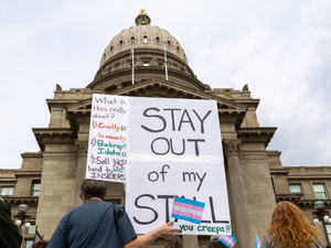 At a Transgender Day of Visibility rally on March 31, in front of the Idaho State Capitol, a person holds a sign criticizing the Legislature's criminal ban on transgender people using bathrooms that align with their gender identity. (Photo by Kyle Pfannenstiel/Idaho Capital Sun)