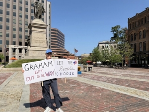 Portland, Maine, resident Alex Kasser, a Democrat, protests in Monument Square on July 8. (By Emma Davis/Maine Morning Star)