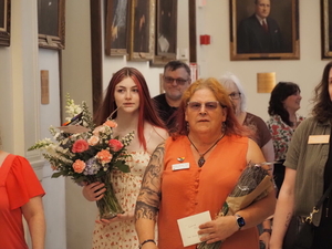 At the New Hampshire State House on Tuesday, June 16, advocates for LGBTQ+ rights deliver flowers and postcards to Gov. Kelly Ayotte's office, imploring her to veto the anti-trans Senate Bill 552, which she did. Pictured are Parker Tirrell (left) and Willow Young (center). (Photo by Molly Rains, New Hampshire Bulletin)