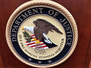 The U.S. Department of Justice logo is displayed on a speaker’s podium at the federal courthouse in Rapid City, South Dakota, on July 21, 2026. (Photo by Seth Tupper/South Dakota Searchlight)