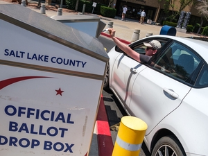 A voter drops off a ballot on primary Election Day at the Salt Lake County Government Center on Tuesday, June 23, 2026. (Photo by Marco Lozzi for Utah News Dispatch)