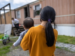 A 10-year-old Honduran immigrant who came into the United States as an unaccompanied minor carries her baby cousin on April 25, 2021, after reuniting with extended family in Sellersburg, Indiana. (Photo by John Moore/Getty Images)