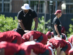 University of Oklahoma football coach helps players stretch during practice on Aug. 4, 2023. (Photo by Kyle Phillips/For Oklahoma Voice)