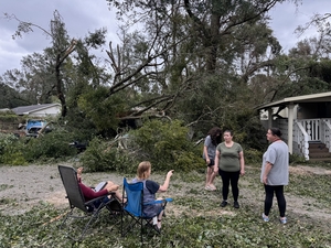 Cher Stanturf, her daughters and neighbors touch base on Oct. 10, 2026, the morning after Hurricane Isaias ripped through their mobile home park in Pensacola, Florida.