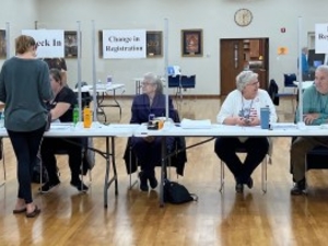Election volunteers help voters check in and register at the Restoration Church polling center in Casper on Nov. 8, 2022. (Dustin Bleizeffer/WyoFile)