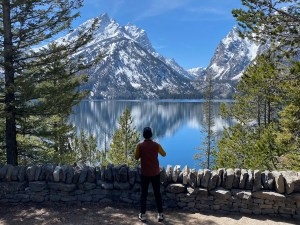 A visitor enjoys the Jenny Lake Overlook in Grand Teton National Park on June 3, 2026, a roadside pullout that was rehabilitated as part of a public-private project costing more than $6 million in park funds and $14.5 million in private donations. (Angus M. Thuermer Jr./WyoFile)