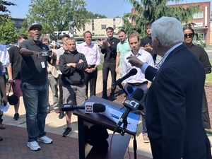 On a sidewalk, Larson denounces ICE and gets a challenge from radio host