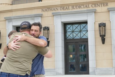 Operation Save America National Director Jason Storms hugs a fellow anti-abortion leader. (John McCosh/Georgia Recorder)