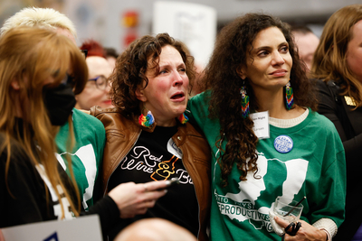 Shannon Gallagher from Brooklyn, New York (center), and Tina Gasbarra Larsen from Union City react to the early election results at the Issue 1 election night party hosted by Ohioans United for Reproductive Rights and Pro-Choice Ohio on Tuesday in Columbus, Ohio. (Graham Stokes for Ohio Capital Journal.