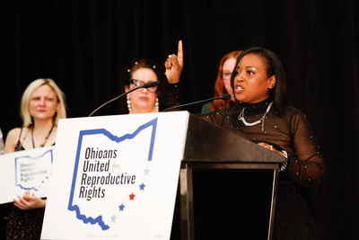 Rhiannon Carnes, executive director of Ohio Women’s Alliance, celebrates the early results at the Issue 1 election night watch party at the Hyatt Regency Downtown in Columbus on Tuesday night. (Graham Stokes for Ohio Capital Journal)