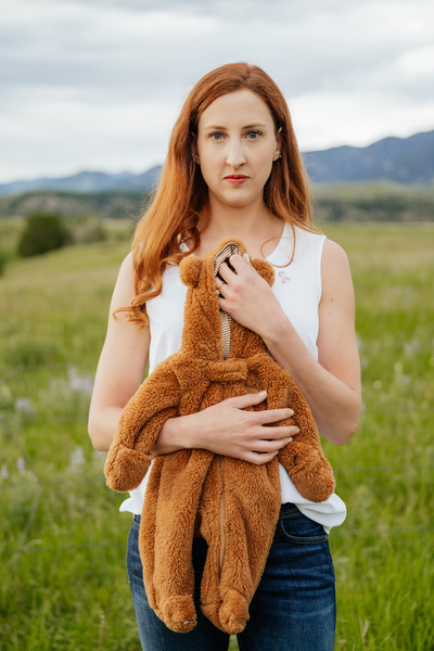Anne Angus, of Montana, holds the teddy bear onesie she purchased when she was about halfway through her first pregnancy, which she had to terminate because of severe fetal defects. (Courtesy of Anne Angus)