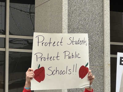 A demonstrator stands outside the U.S. Education Department in Washington, D.C. (Photo by Shauneen Miranda/States Newsroom)