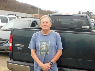 Larry Burnette stands in front of a pick-up truck