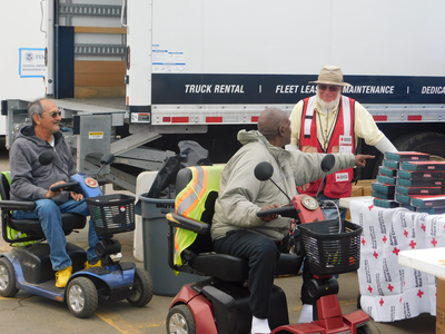 residents pick up provisions in a parking lot