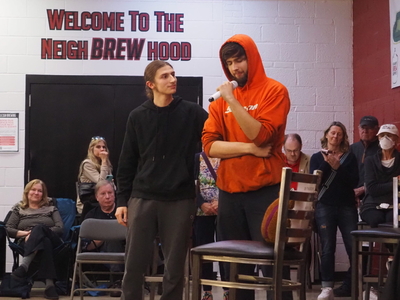 Aden Kalinowski looks up at his brother Jake Kalinowski as they speak to a crowd at the Raleigh Brewing Company.