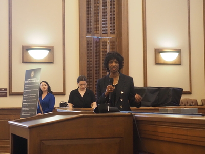 Rep. Valerie Foushee stands in a courtroom and speaks into a microphone.
