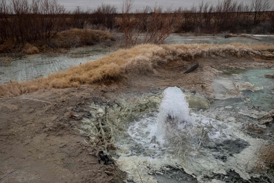 Water flows up from a broken old oil well in northern Pecos County in February 2023.