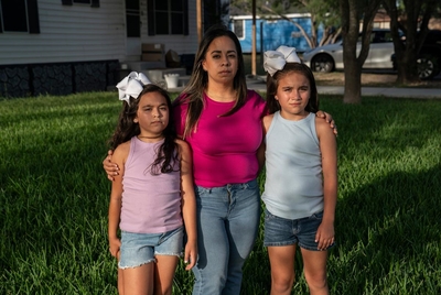 Clarissa Méndez, 44, and her daughters Catiana Ester Méndez, 7, left, and Catalaya Avaneh Méndez, 8, pose for a photo at their home in Hebbronville, Texas on July 30, 2025. Méndez makes a daily one-hour commute to Laredo to work as a nurse. Currently she has her father or another person pick up her daughters from the daycare and take care of them for about an hour until she comes back from work. After picking up her daughters she cooks for them and spends some time with them before she starts working fr